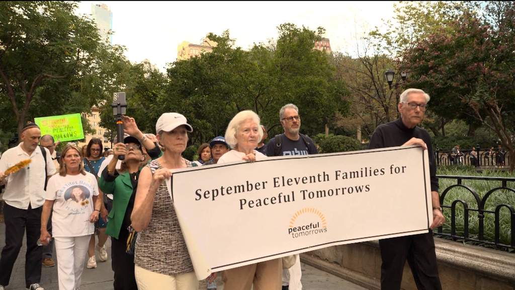 Participants holding candles during a memorial walk and candlelight vigil at ground zero in New York City ahead of the 25th anniversary of the September 11 attacks.