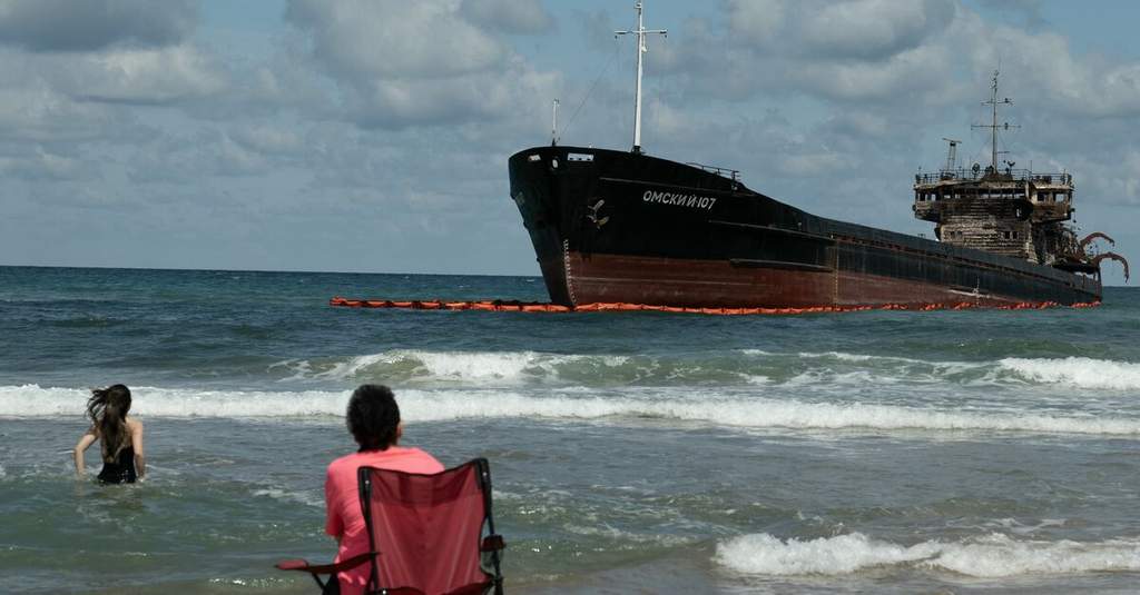 A commercial cargo vessel sailing through the turbulent waters of the Black Sea under an overcast sky.
