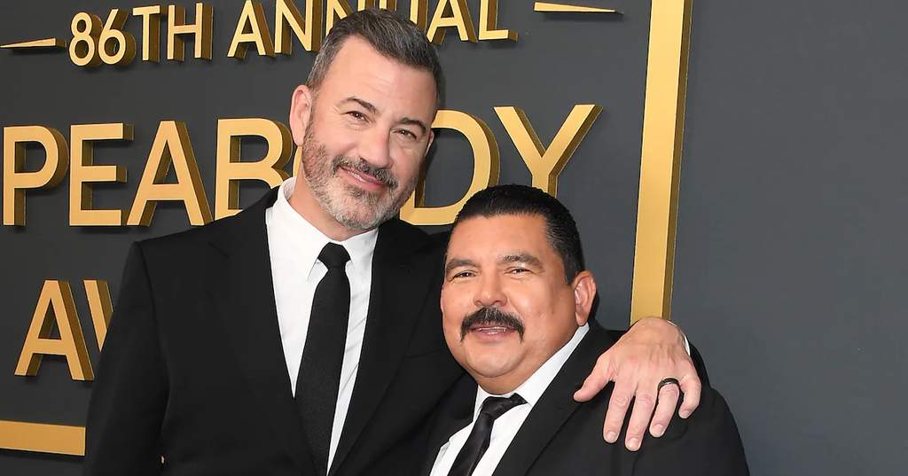 Guillermo Rodriguez posing with two thumbs up at the 86th Annual Peabody Awards in Beverly Hills, California, wearing a dark suit.